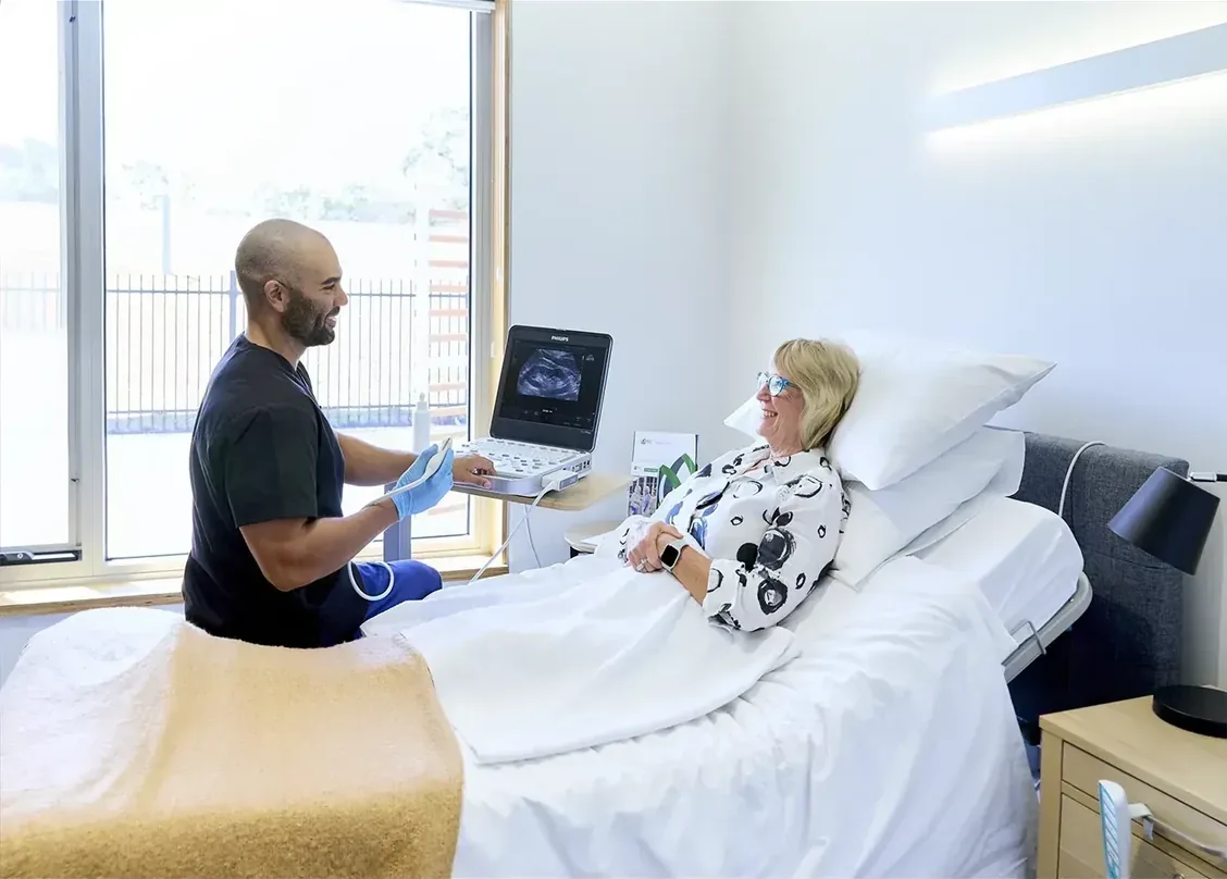 A sonographer performing a bedside ultrasound examination